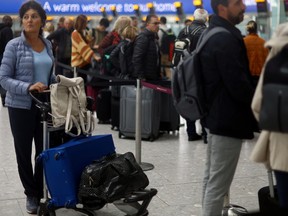 Passengers queue for the check in desk at Heathrow Terminal 5 airport in London, June 1, 2022.