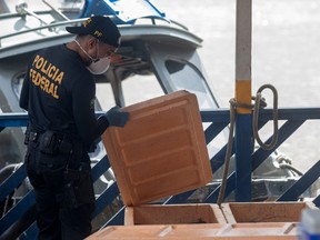 A Federal Police expert examines a boat seized by the Task Force for the rescue of Indigenist Bruno Pereira and Journalist Dom Phillips at the port of the city of Atalaia do Norte, Amazonas, Brazil, on June 11, 2022.