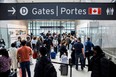 Travellers crowd the security queue in the departures lounge at the start of the Victoria Day holiday long weekend at Toronto Pearson International Airport in Mississauga on May 20, 2022.