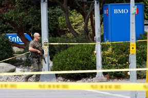 Ein Polizist schaut zu, nachdem zwei bewaffnete Männer, die eine Bank betreten, bei einer Schießerei mit der Polizei in Saanich, British Columbia, am 28. Juni 2022 getötet wurden. REUTERS/Kevin Light