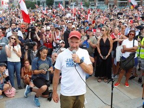 James Topp, ein Veteran der kanadischen Streitkräfte, der aus Protest gegen die COVID-19-Mandate durch Kanada marschierte, spricht mit Unterstützern, als er vor dem Canada Day in Ottawa am 30. Juni 2022 am Grab des unbekannten Soldaten und am National War Memorial ankommt.