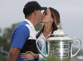 Brooks Koepka, left, kisses Jena Sims after winning the PGA Championship golf tournament, Sunday, May 19, 2019, at Bethpage Black in Farmingdale, N.Y.