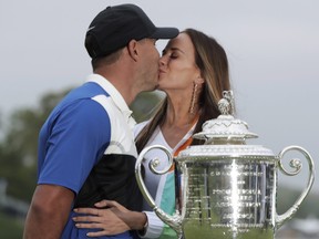 Brooks Koepka, left, kisses Jena Sims after winning the PGA Championship golf tournament, Sunday, May 19, 2019, at Bethpage Black in Farmingdale, NY