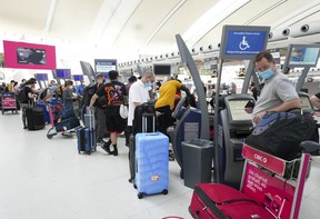 People wait in line to check in at Pearson International Airport in Toronto on Thursday, May 12, 2022.