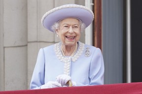 Königin Elizabeth lächelt, als sie vom Balkon des Buckingham Palace nach der Trooping the Colour-Zeremonie in London am Donnerstag, den 2. Juni 2022, am ersten von vier Tagen der Feierlichkeiten zum Platinjubiläum zusieht.  (Jonathan Brady/Pool-Foto über AP)