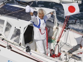 Japan's Kenichi Horie waves on his sailing boat after his trans-Pacific voyage, at Osaka Bay, western Japan, Saturday, June 4, 2022.