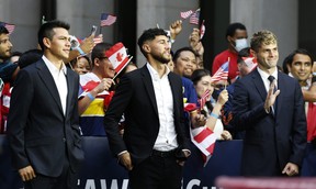 International soccer players, from left, Hirving “Chucky” Lozano, Jonathan Osorio and Christian Pulisic wait along 6th Ave. for FIFA’s announcement of the names of the host cities for the 2026 World Cup soccer tournament, June 16, 2022, in New York.
