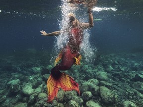 Queen Pangke Tabora swims in her mermaid suit while she conducts a mermaiding class in front of the Ocean Camp in Mabini, Batangas province, Philippines on Sunday, May 22, 2022.