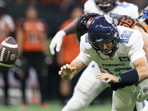 Toronto Argonauts' quarterback Chad Kelly looses the ball while getting sacked by BC Lions' David Menard during second half of CFL football action in Vancouver, B.C., Saturday, June 25, 2022.