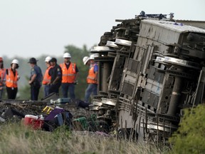 Workers inspect the scene of an Amtrak train which derailed after striking a dump truck Monday, June 27, 2022, near Mendon, Mo.