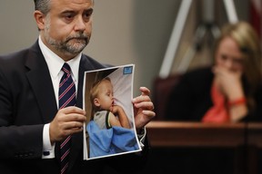 In this Oct. 31, 2016, file photo, defence attorney Maddox Kilgore holds a photo of Cooper Harris during a murder trial for his father Justin Ross Harris who is accused of intentionally killing him in June 2014 by leaving him in the car in suburban Atlanta, in Brunswick, Ga. (AP Photo/John Bazemore, Pool, File)