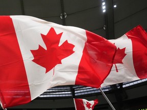 Fans wave Canadian flags before Canada and Curacao play a CONCACAF Nations League soccer match, in Vancouver, on Thursday, June 9, 2022. THE CANADIAN PRESS/Darryl Dyck