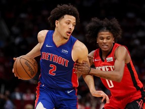 Cade Cunningham #2 of the Detroit Pistons controls the ball ahead of Jalen Green #0 of the Houston Rockets during the second half at Toyota Center