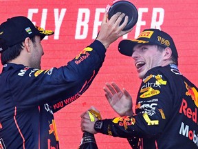 Max Verstappen (right) and Sergio Perez celebrate on the podium after the Formula One Azerbaijan Grand Prix at the Baku City Circuit in Baku on June 12, 2022.