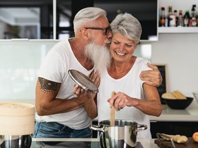 Happy senior couple having fun cooking together at home