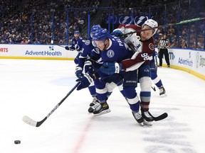 Nicholas Paul of the Tampa Bay Lightning and Mikko Rantanen of the Colorado Avalanche battle for the puck during the first period in Game Three of the 2022 NHL Stanley Cup Final at Amalie Arena on June 20, 2022 in Tampa, Florida.