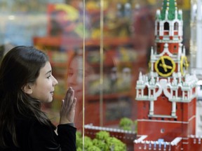 A girl looks at a model of the Kremlin's Spasskaya (Saviour) Tower made from lego bricks at the Central Children's Store at Moscow's Lubyanka square on March 31, 2015.