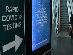 A pilot walks past a sign for COVID-19 testing at Dublin Airport December 3, 2021.