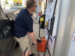 Allan fills an extra gas canister to take advantage of a lower price on Wednesday. He wants Canada to pump more oil to drive down gas prices. SCOTT LAURIE/TORONTO SUN
