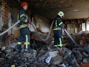 Firefighters secure a partially destroyed educational and laboratory building of a college hit the day before by a rocket in Kharkiv on June 21, 2022.