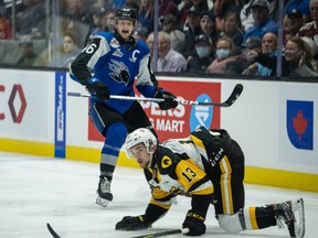 Saint John Sea Dogs captain Vincent Sevigny takes a shot from the point past Hamilton Bulldogs forward Avery Hayes in the Memorial Cup Final at Harbour Station arena in Saint John, N.B., on June 29, 2022.