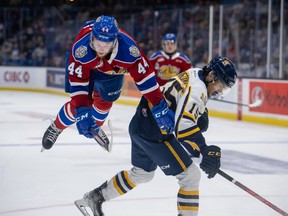 Carter Souch (44) of the Edmonton Oil Kings gets airborn after being check by Loris Rafanomezantsoa (15) of the Shawinigan Cataractes during the first period at the 2022 Memorial Cup on June 21, 2022, at the Harbour Station in Saint John, NB.