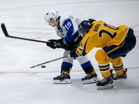 Josh Lawrence (18) of the Saint John Sea Dogs skates with the puck away from Olivier Nadeau (20) of the Shawinigan Cataractes during the 2022 Memorial Cup on June 25, 2022,  at the Harbour Station in Saint John, NB.