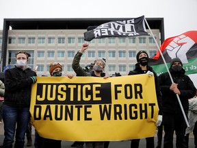 Demonstrators hold a banner in front of the FBI Minneapolis Division building as they march days after Daunte Wright, 20, was shot and killed by former Brooklyn Center Police Officer Kim Potter, in Brooklyn Center, Minnesota, April 13, 2021.