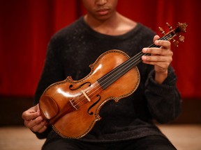 Violinist Braimah Kanneh-Mason holds the rare 'Hellier' violin, created by Italian luthier Antonio Stradivari in 1679, which will be offered in the Exceptional Sale at Christie's auction house in London, Britain, May 30, 2022.