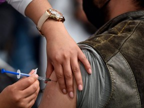 A nurse inoculates a man with a booster dose of the AstraZeneca vaccine against COVID-19 in Mexico City, Feb. 15, 2022.