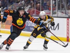 William Dufour (28) of the Saint John Sea Dogs and Nathan Staios (44) of the Hamilton Bulldogs race for the puck during the third period of the opening game of the 2022 Memorial Cup at the Harbour Station in Saint John, N.B., on June 20, 2022.