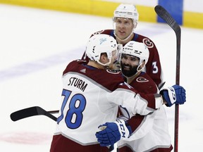 Avalanche forward Nazim Qadri, right, celebrates with Nico Storm, left, and Jack Johnson after scoring an overtime goal to defeat Lightning 3-2 in Game 4 of the NHL Stanley Cup Final at Amalie Arena in Tampa, Florida, Wednesday, June 22, 2022.