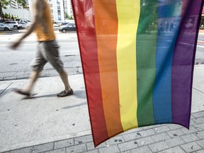 A pedestrian walks past the Pride flag on Church Street on Monday, Aug. 19, 2019.