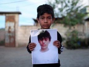 Alfonso holds a picture of 13-year-old Pascual Melvin Guachiac who died in a tractor-trailer along with other migrants in San Antonio, Texas, at the small village of Tzucubal, in Nahuala, Guatemala, Wednesday, June 29, 2022.