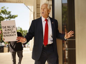 Pursued by a demonstrator, former Trump White House Advisor Peter Navarro briefly speaks to journalists as he arrives for his arraignment at the Prettyman U.S. Courthouse on June 17, 2022 in Washington.