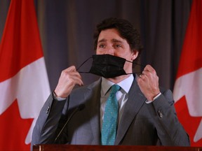 Prime Minister Justin Trudeau removes his protective mask before speaking to attendees during a Liberal fundraiser at the Fairmont Hotel conference room in Vancouver, on Tuesday, March 29, 2022.