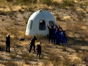 The occupants of Blue Origin's fifth crewed capsule mission pose for photographs after landing near Van Horn, Texas, June 4, 2022 in a still image from video.