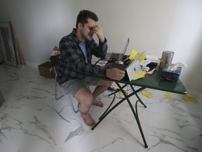 Harrison Browne, who allegedly fell victim to a moving scam that recently led Toronto Police to arrest two men, sits in his empty downtown Toronto apartment on Monday, June 27, 2022.