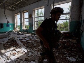 A police officer checks a school during an evacuation of local residents between shelling, amid Russia's attack on Ukraine, in the town of Marinka, in Donetsk region, Ukraine May 31, 2022.