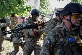 Mitglieder einer ausländischen Freiwilligeneinheit, die in der ukrainischen Armee kämpft, gehen während Russlands Angriff auf die Ukraine am 2. Juni 2022 in Sievierodonetsk, Region Lugansk, Ukraine, spazieren
