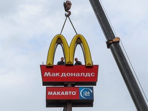Arbeiter verwenden einen Kran, um die Goldenen Bögen von McDonald's abzubauen, während sie die Logo-Beschilderung von einem Drive-Through-Restaurant von McDonald's in der Stadt Kingisepp in der Region Leningrad, Russland, am 8. Juni 2022 entfernen.