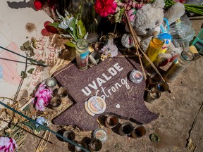 A sign surrounded by gifts is seen at a memorial in front of Robb Elementary School on June 17, 2022 in Uvalde, Texas.
