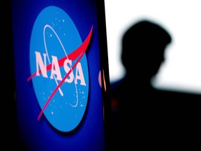 The silhouette of US engineer and NASA astronaut Megan McArthur is seen past the NASA logo in the Webb Auditorium at NASA headquarters in Washington, DC, on June 7, 2022.