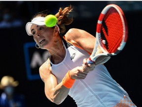 France's Alize Cornet hits a return against Spain's Garbine Muguruza during their women's singles match on day four of the Australian Open tennis tournament in Melbourne on January 20, 2022.