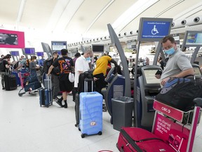 People wait in line to check in at Pearson International Airport in Toronto on Thursday, May 12, 2022.