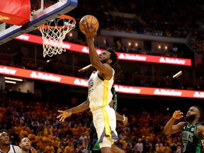 Andrew Wiggins of the Golden State Warriors drives to the basket against Robert Williams III and Jaylen Brown of the Boston Celtics during the fourth quarter in Game 5 of the 2022 NBA Finals at Chase Center on June 13, 2022 in San Francisco, Calif.