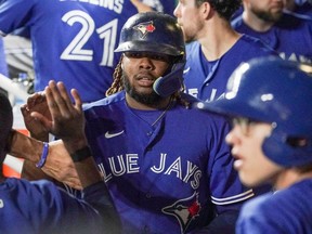 Toronto Blue Jays first baseman Vladimir Guerrero Jr. (27) is congratulated in the dugout after scoring against the Kansas City Royals in the ninth inning at Kauffman Stadium.
