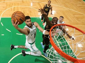 Boston Celtics forward Jayson Tatum (0) attempts a basket in front of Golden State Warriors forward Draymond Green (23) in the second half during game three of the 2022 NBA Finals at TD Garden.
