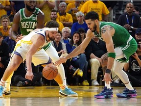 Golden State Warriors guard Klay Thompson and Boston Celtics forward Jayson Tatum battle for a loose ball during the second half in game one of the 2022 NBA Finals at Chase Center.