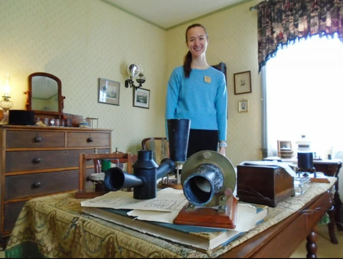 Bell Homestead guide Jillian with some of the telephone prototype replicas in Alexander's study.